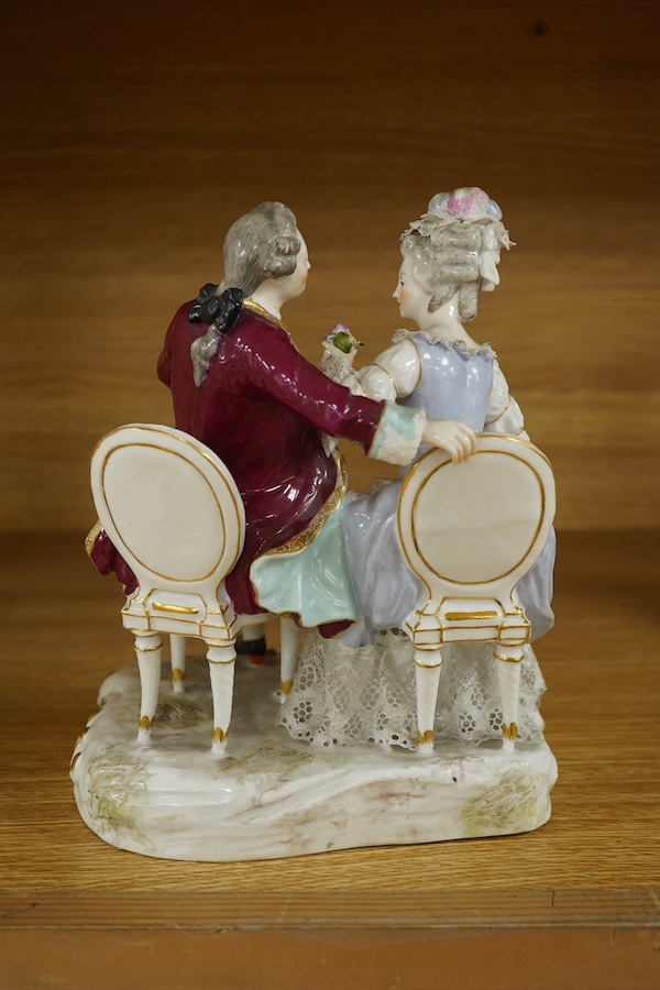 A Sitzendorf tete-a-tete porcelain figure group, signed to the base, 21cm high. Condition - fair, some losses and firing cracks